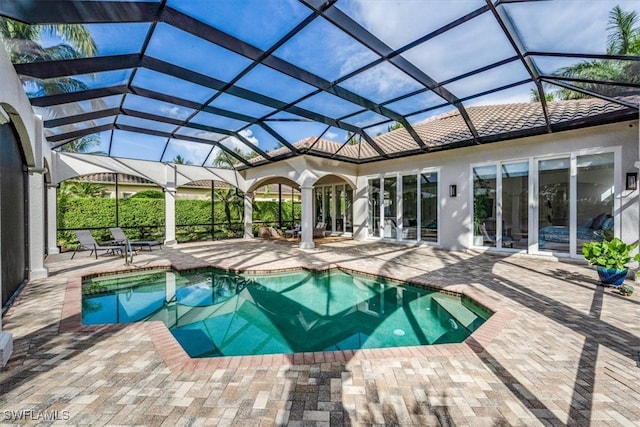 view of pool with glass enclosure and a patio