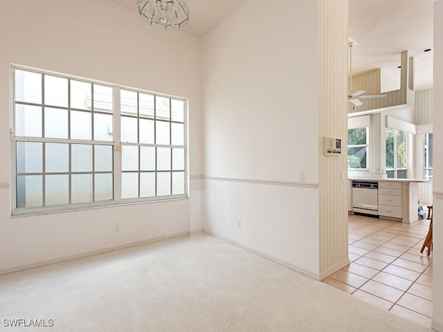 584 Eagle Creek Dr, Naples, FL 34113 - spare room with light carpet, a chandelier, light tile patterned floors, a towering ceiling, and baseboards