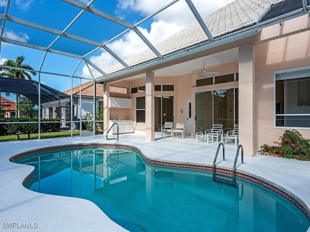 view of pool with ceiling fan, a patio area, and a lanai