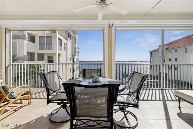 sunroom / solarium featuring a water view, plenty of natural light, and ceiling fan