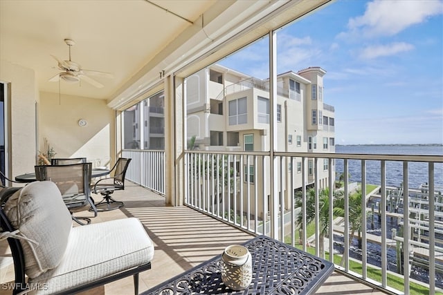 balcony with ceiling fan and a water view