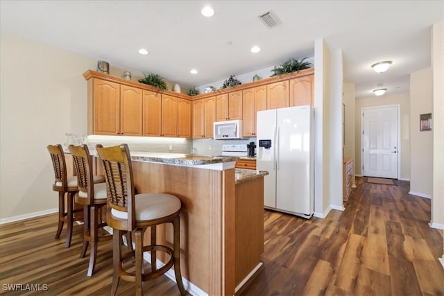 kitchen featuring white appliances, a kitchen breakfast bar, light stone countertops, tasteful backsplash, and dark hardwood / wood-style flooring