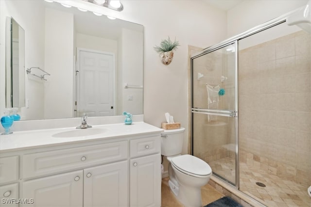 bathroom featuring tile patterned floors, vanity, toilet, and a shower with shower door