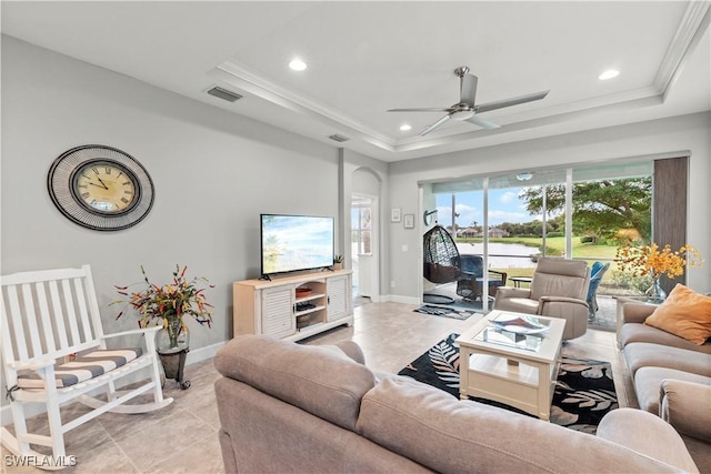 tiled living room with crown molding, ceiling fan, and a tray ceiling