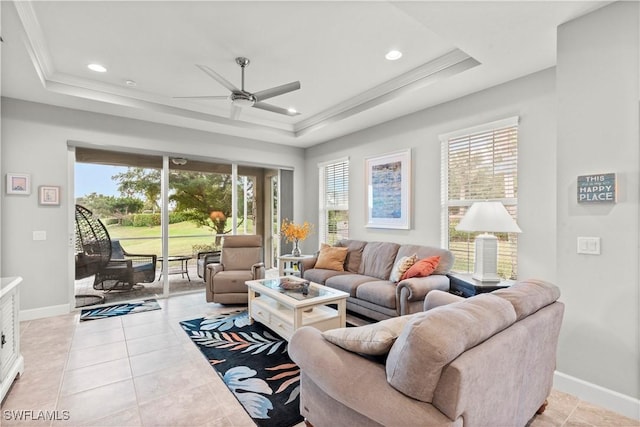 living room with crown molding, a raised ceiling, ceiling fan, and light tile patterned flooring