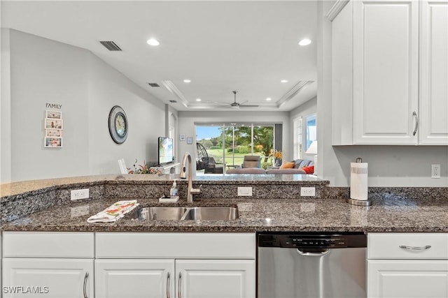 kitchen featuring sink, ceiling fan, white cabinetry, stainless steel dishwasher, and dark stone counters