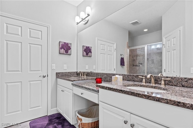 bathroom featuring an enclosed shower and vanity