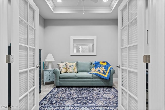 tiled living room featuring french doors, a tray ceiling, and crown molding