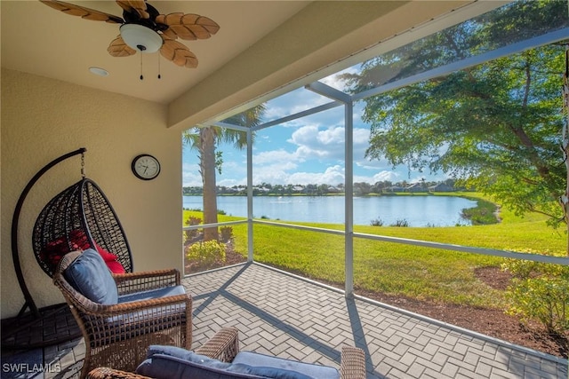 sunroom featuring a water view and ceiling fan