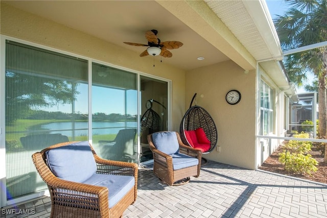 view of patio / terrace with ceiling fan and a water view