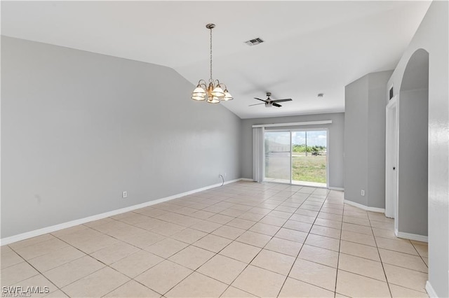 tiled empty room featuring ceiling fan with notable chandelier and vaulted ceiling