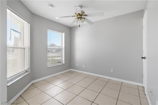 tiled spare room featuring ceiling fan and a healthy amount of sunlight