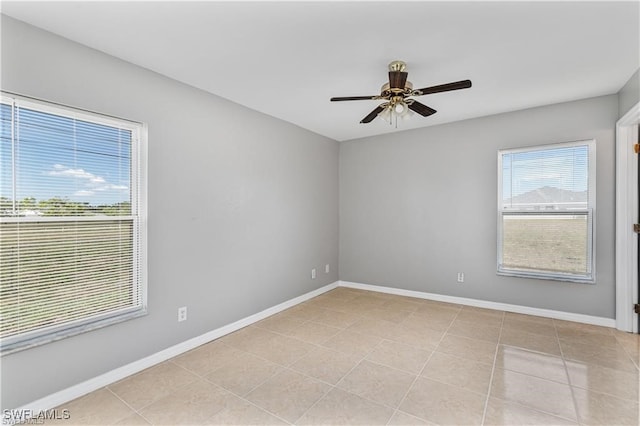 tiled spare room featuring ceiling fan