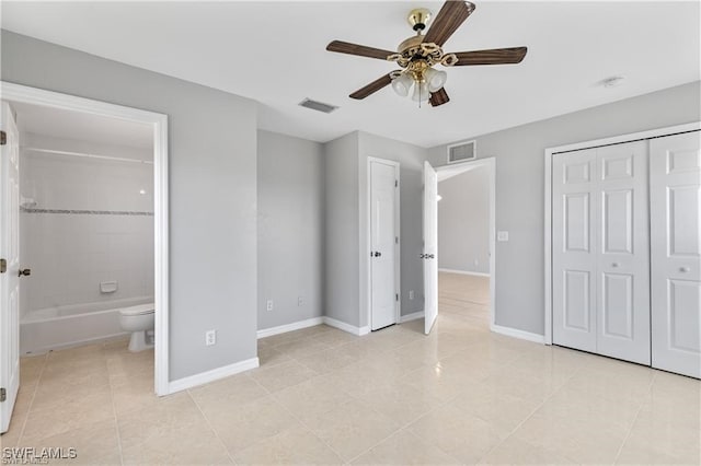 unfurnished bedroom with light tile patterned floors, ensuite bathroom, and ceiling fan