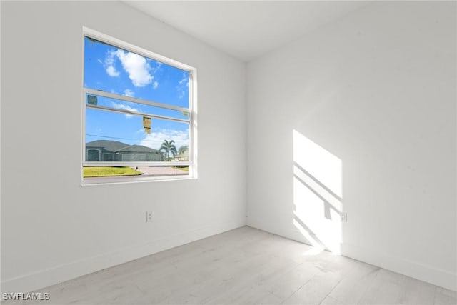 spare room with light wood-type flooring and baseboards