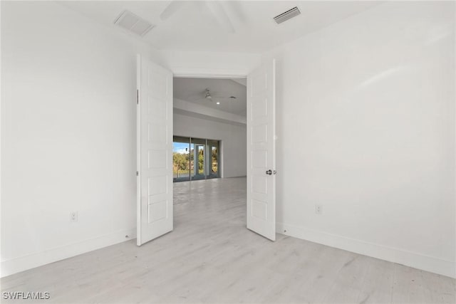 unfurnished room featuring baseboards, light wood finished floors, visible vents, and a ceiling fan