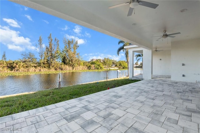 view of patio with a ceiling fan and a water view