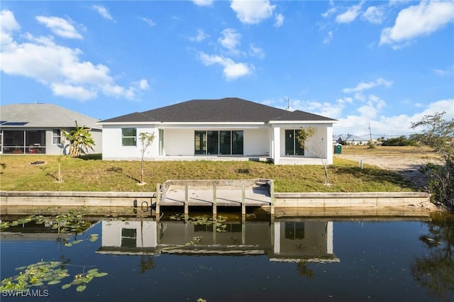 rear view of house with a lawn and a water view