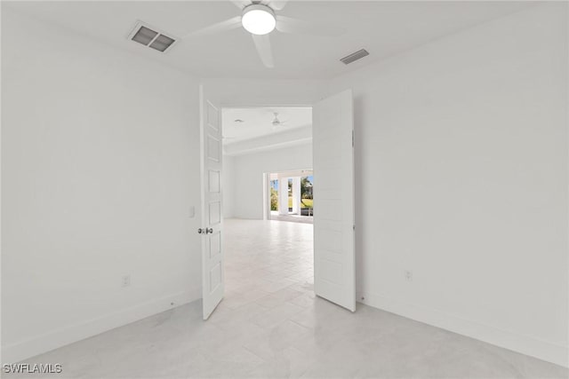 unfurnished room featuring baseboards, visible vents, and a ceiling fan