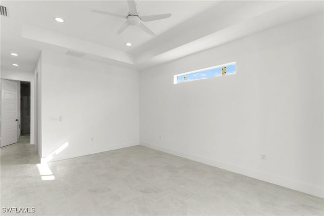 spare room featuring recessed lighting, a raised ceiling, ceiling fan, and baseboards