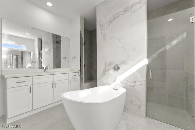 bathroom with a stall shower, a soaking tub, and vanity