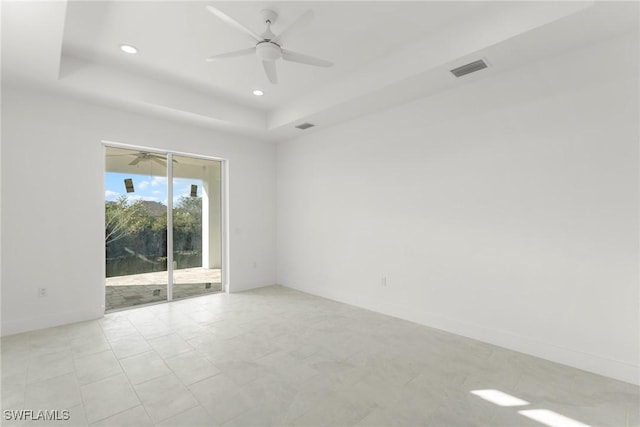 empty room with recessed lighting, a raised ceiling, visible vents, ceiling fan, and baseboards