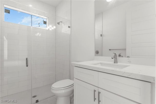 bathroom featuring walk in shower, vanity, and toilet