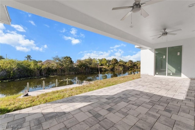 view of patio / terrace featuring a water view and ceiling fan