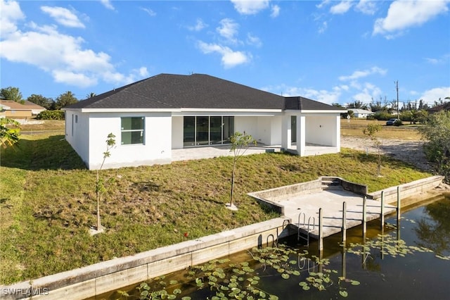 rear view of house featuring a yard, a water view, and a patio area