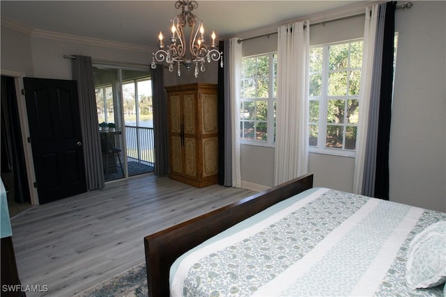 bedroom with a notable chandelier, hardwood / wood-style flooring, access to outside, and ornamental molding