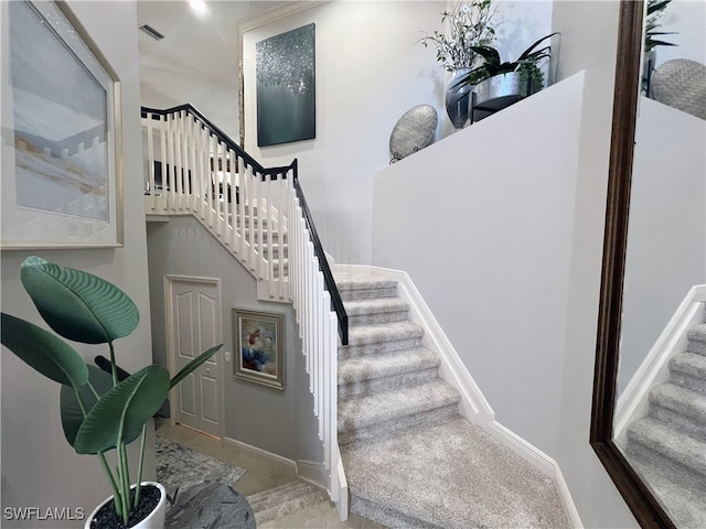 stairway featuring carpet flooring