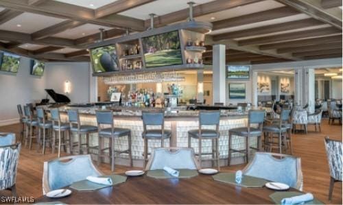 bar with wood-type flooring and beamed ceiling