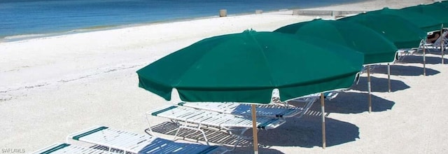 view of pool featuring a view of the beach and a water view