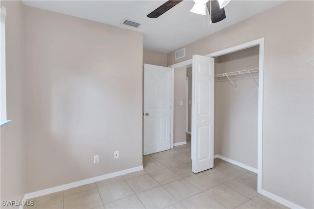 unfurnished bedroom with ceiling fan, light tile patterned floors, and a closet