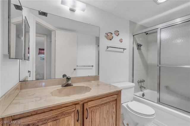 full bathroom featuring shower / bath combination with glass door, vanity, and toilet