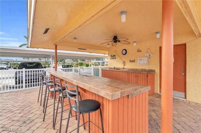 view of patio / terrace with an outdoor bar and ceiling fan