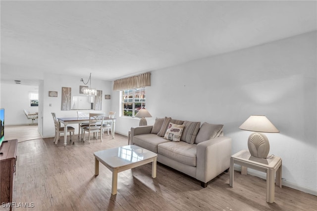 living room with an inviting chandelier and hardwood / wood-style flooring