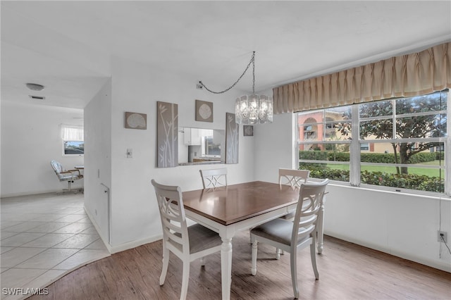 dining area with a chandelier and light hardwood / wood-style floors