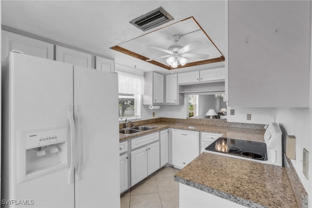 kitchen with white cabinetry, sink, a raised ceiling, white appliances, and light tile patterned floors