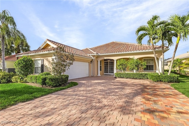 mediterranean / spanish home featuring a porch and a garage