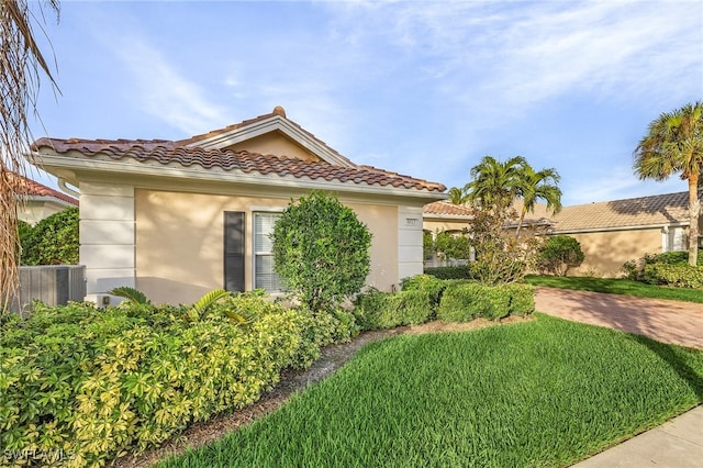 view of front of home featuring a front lawn and cooling unit