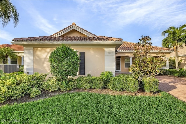 mediterranean / spanish home with central air condition unit and a front yard