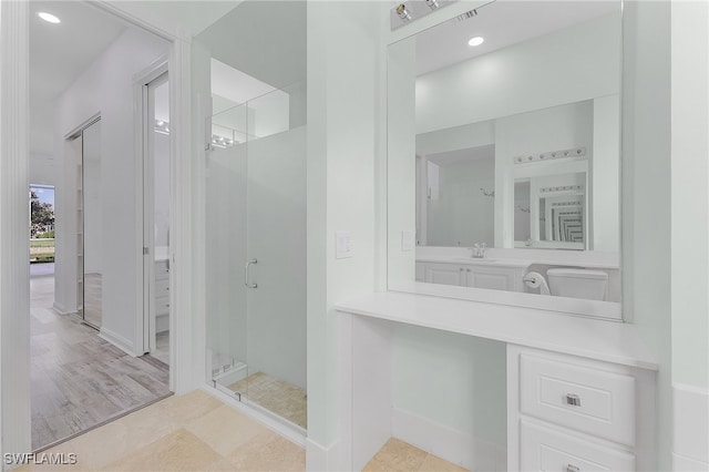 bathroom featuring hardwood / wood-style flooring, vanity, and walk in shower