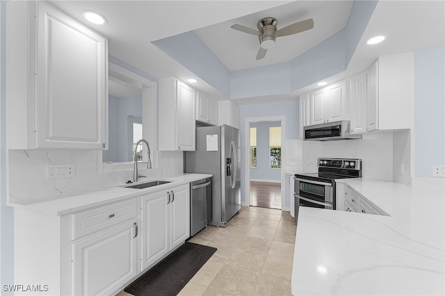 kitchen with appliances with stainless steel finishes, white cabinetry, and sink