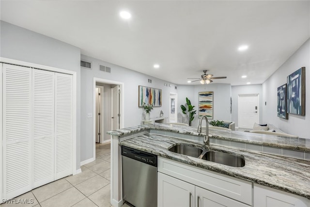 kitchen featuring stainless steel dishwasher, white cabinetry, sink, and light tile patterned floors