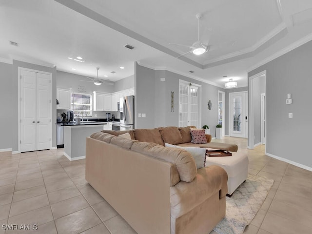 tiled living room with crown molding and ceiling fan