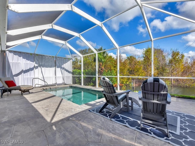 view of pool with a lanai, a water view, and a patio