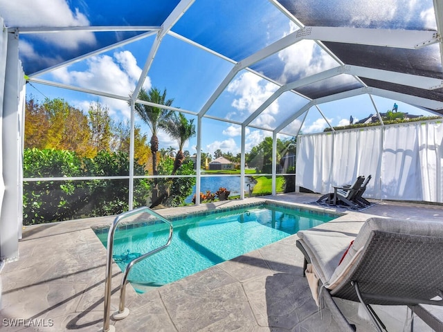 view of pool featuring glass enclosure, a water view, and a patio