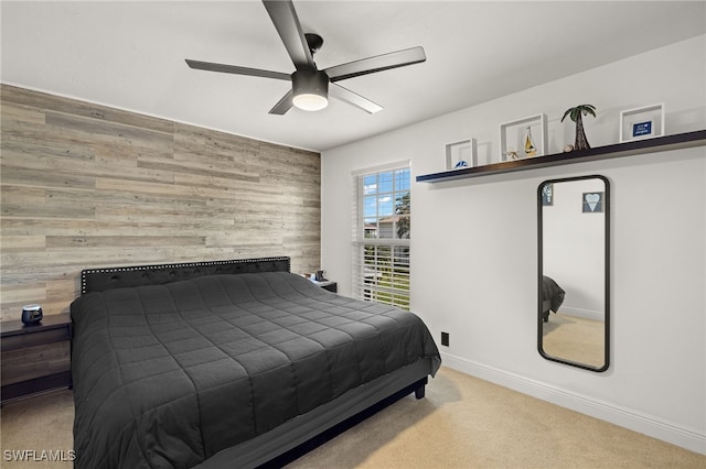 carpeted bedroom with ceiling fan and wooden walls