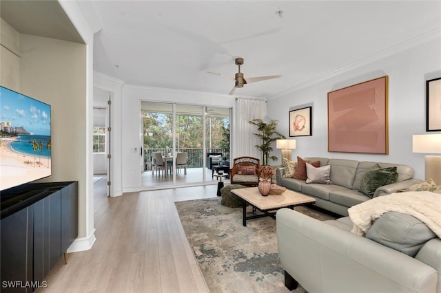 living room featuring light hardwood / wood-style flooring, ceiling fan, and crown molding